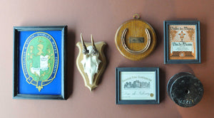 Variety of of pictures, labels, roe horns, and architectural details that create a gallery wall.